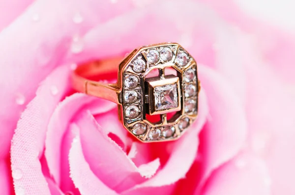 Goldener Ring und Rose im Hintergrund — Stockfoto