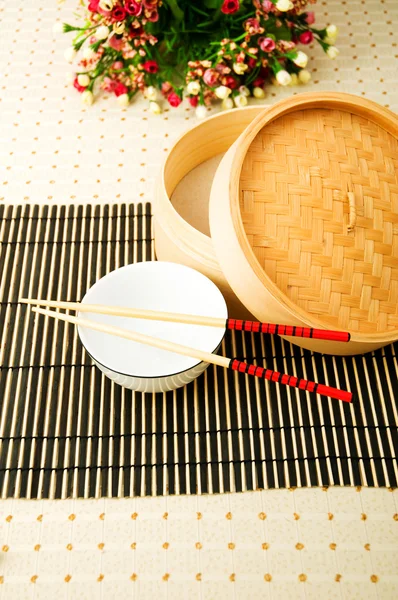 Chopsticks and bowl on the mat — Stock Photo, Image
