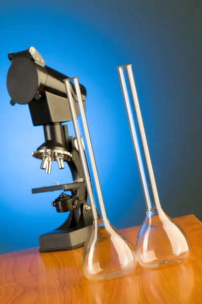 Микроскоп против синего градиента — стоковое фото