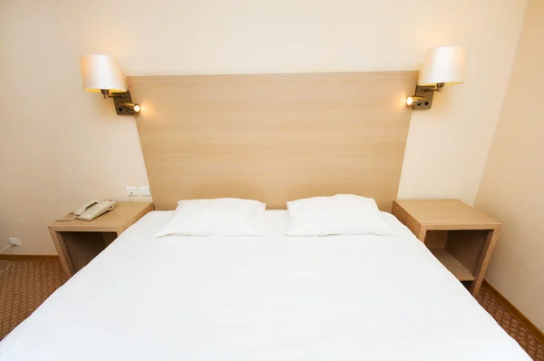 在酒店房间里的大床 免版税图库图片