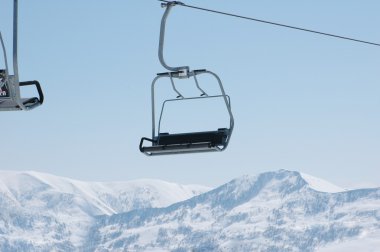 Ski lift chairs on bright day clipart