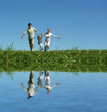 Family on herb under blue sky clipart