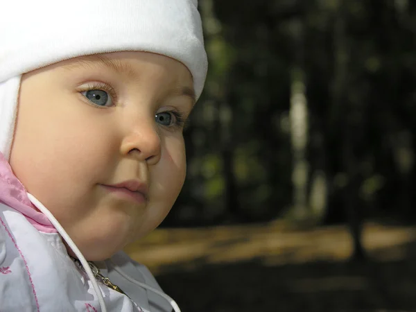 Πρόσωπο του μωρού στο φθινόπωρο ξύλο — Φωτογραφία Αρχείου