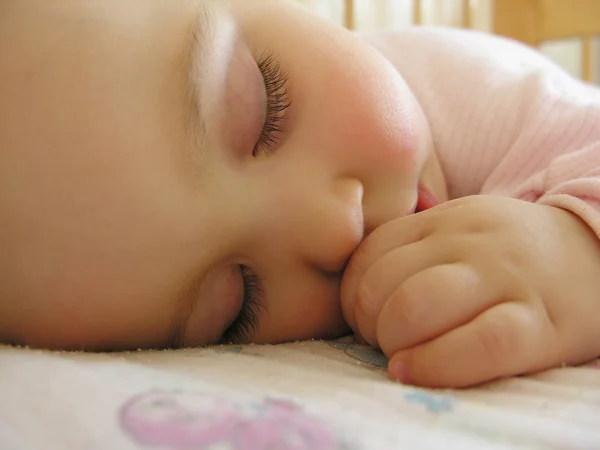 Slapende baby met hand — Stockfoto