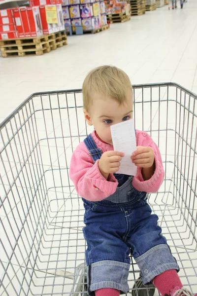Bebé en shopingcart ver cheque —  Fotos de Stock