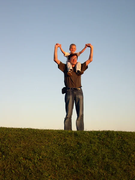 Padre con hijo en hombros al atardecer — Foto de Stock