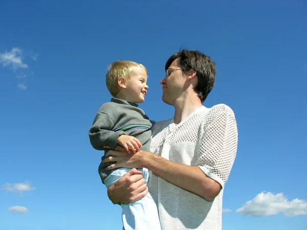 Батько з сином на руках сонячний день — стокове фото