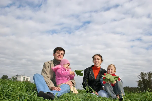 Family of four on autumn grass — Stock Photo, Image