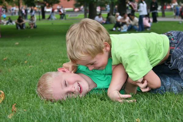 Crianças brincam na grama — Fotografia de Stock