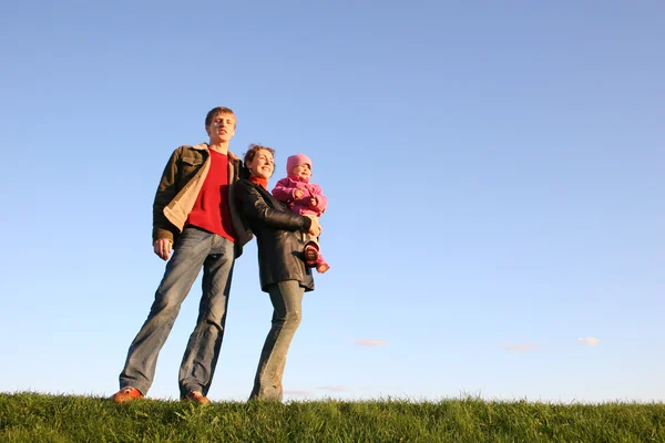 Семья с ребенком стоять на траве — стоковое фото