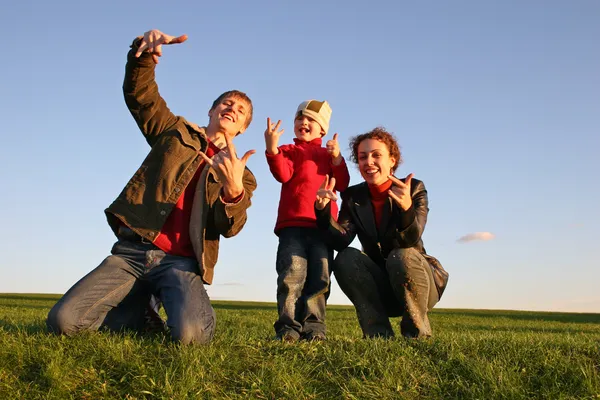 Семья с пальцами на траве — стоковое фото