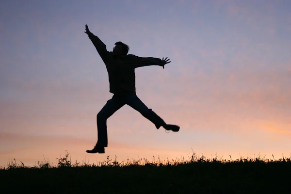 Прыжок человека на закате — стоковое фото