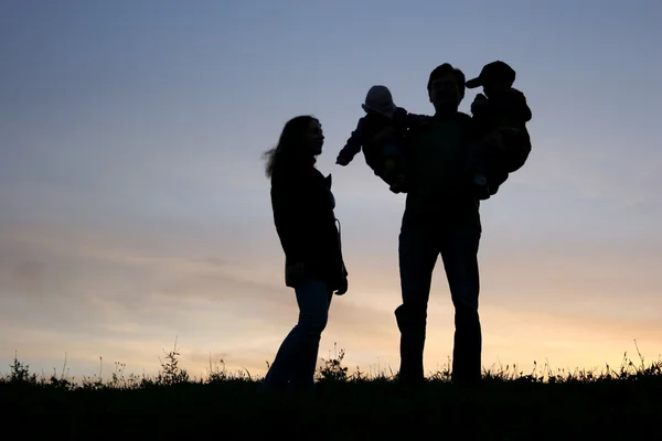 Οικογένεια με παιδιά, στα χέρια, ηλιοβασίλεμα ουρανό — Φωτογραφία Αρχείου