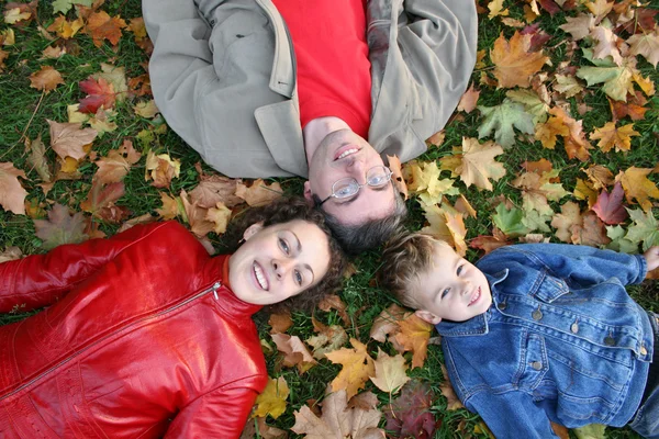 Family lies on maple leaves — Zdjęcie stockowe