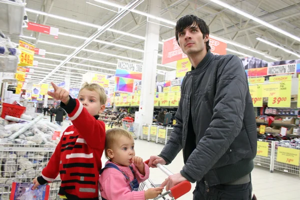 Отец с детьми в магазине — стоковое фото