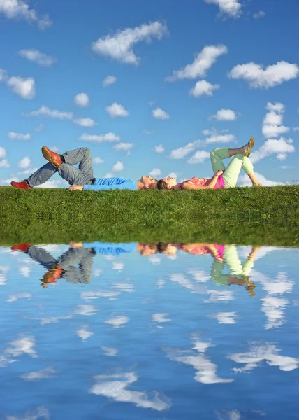 Couple lies under clouds — Stock Photo, Image