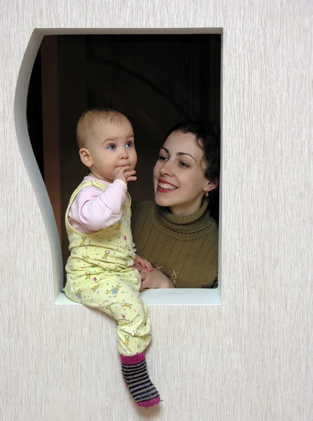 Мать с ребенком в окне — стоковое фото