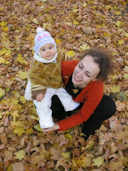 Mother with baby on autumn field from up — Stock Photo, Image