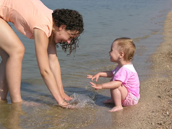 Mamma med barn på stranden — Stockfoto