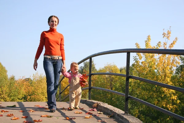 Mother with baby walk on bridge autumn — Stock Photo, Image