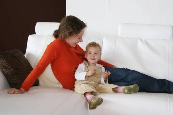 Moeder met baby op sofa — Stockfoto