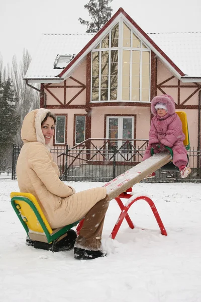Matka z dzieckiem na huśtawce zima — Zdjęcie stockowe