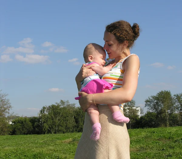 Bebekle çayır üzerinde oturan Anne — Stok fotoğraf