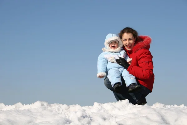Sonrisa madre sentarse con el bebé. invierno — Foto de Stock