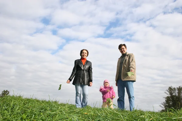 Familj med barn. moln. gräs — Stockfoto