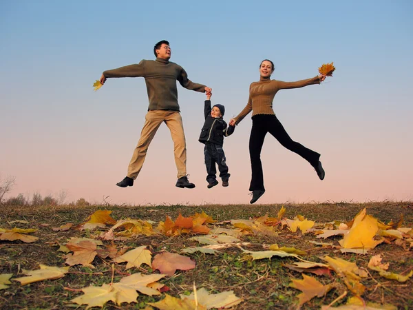 Fly happy family with autumn leaves. color sunset sky — Stock Photo, Image