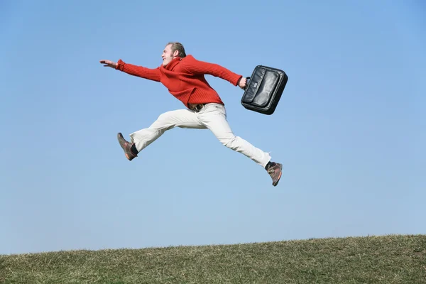 バッグを持つ実行飛ぶ男 — ストック写真