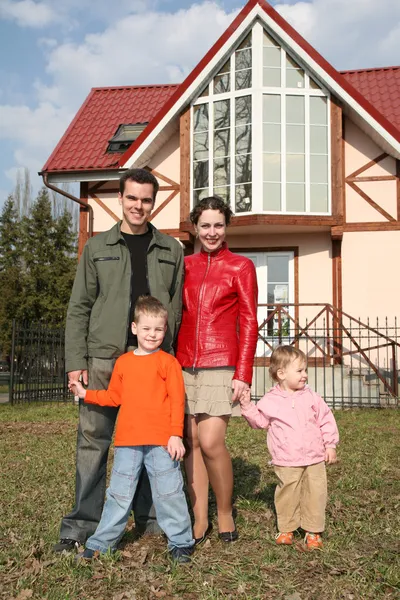 Familia de cuatro y casa — Foto de Stock