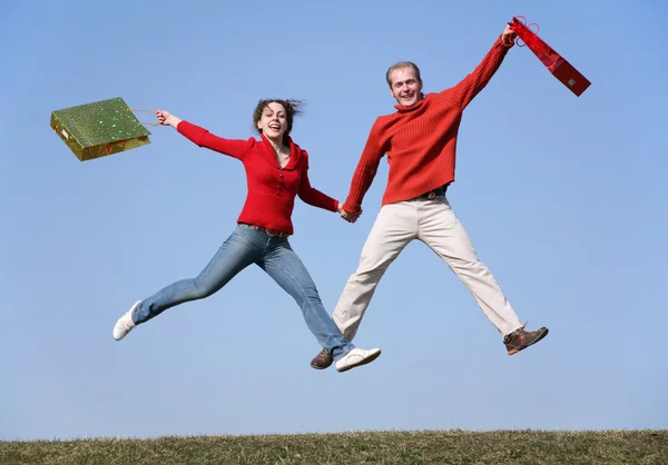 Jump couple with bags — Stock Photo, Image