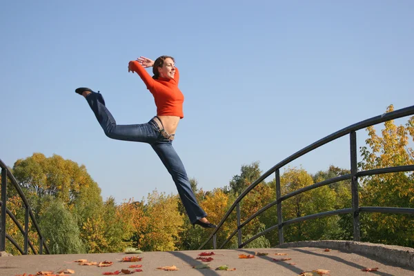 秋天的桥上跳的女孩 — 图库照片