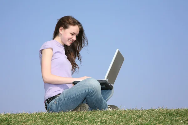 Meisje met laptop op weide — Stockfoto