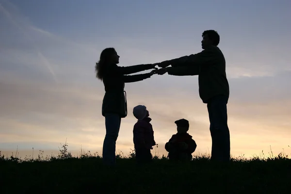 Family of four on sunset sky — Stock Photo, Image