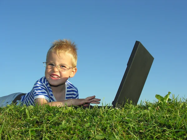 Ребенок с ноутбуком на голубом небе — стоковое фото