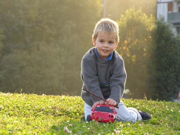 Ребенок играть с автомобилем на закате света — стоковое фото