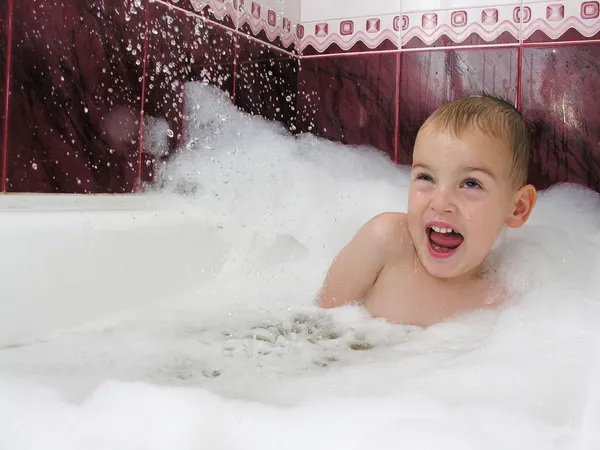Boy in bath hides from streem of water — Stock Photo, Image