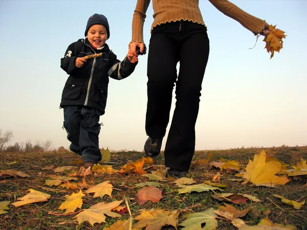 Running kid with half mother. autumn leaves — Stock Photo, Image