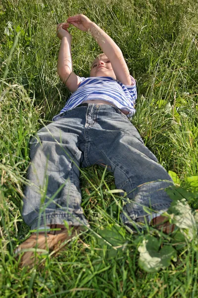 Дитина лежить на траві — стокове фото