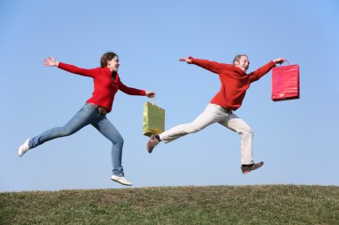 Running couple with bags clipart