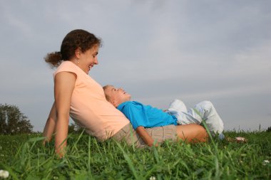 Mother with child on meadow clipart