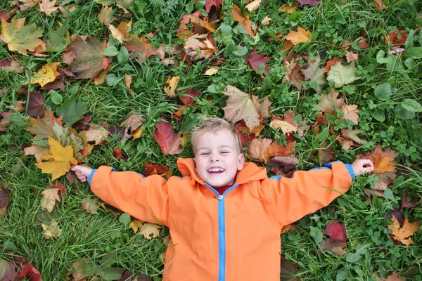 Осенний ребенок лежит — стоковое фото