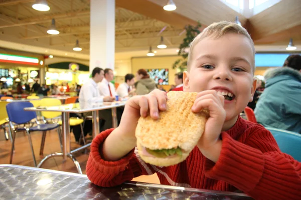 Дитині з'їсти гамбургер — стокове фото