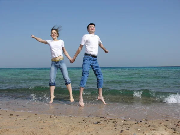 Couple jump. sea. sunny day — Stock Photo, Image