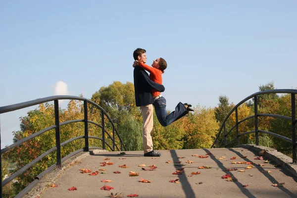 Couple on autumn bridge — Stock Photo, Image