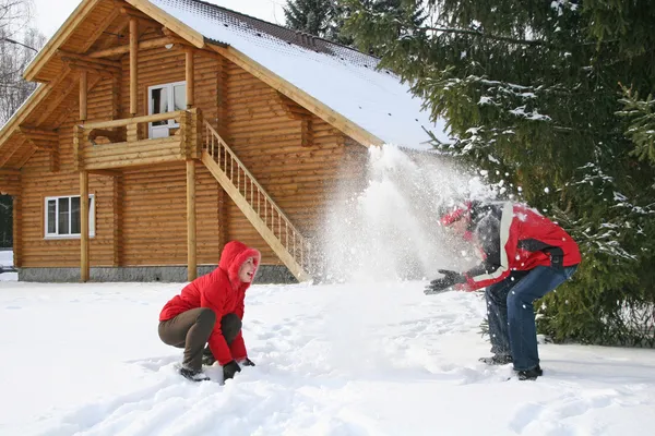 Casal casa de inverno jogar neve — Fotografia de Stock