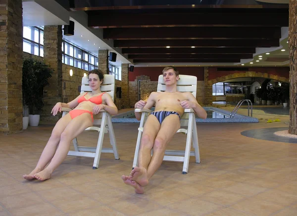 Couple sur chaises longues et piscine — Photo