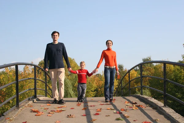 Сім'я з хлопчиком на осінньому мосту — стокове фото